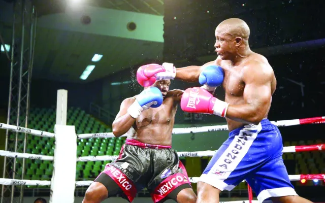 Tanzanian boxer Karim Mandonga (right) exchanges punches with his Ugandan opponent, Kenneth Lukyamuzi in Nairobi on Saturday nigh