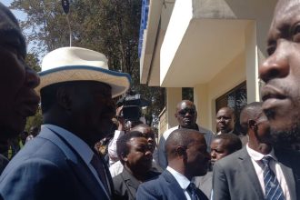 Azimio leader Raila Odinga (wearing a hat) outside the gate of the Directorate of Criminal Investigations (DCI) headquarters on Kiambu Road